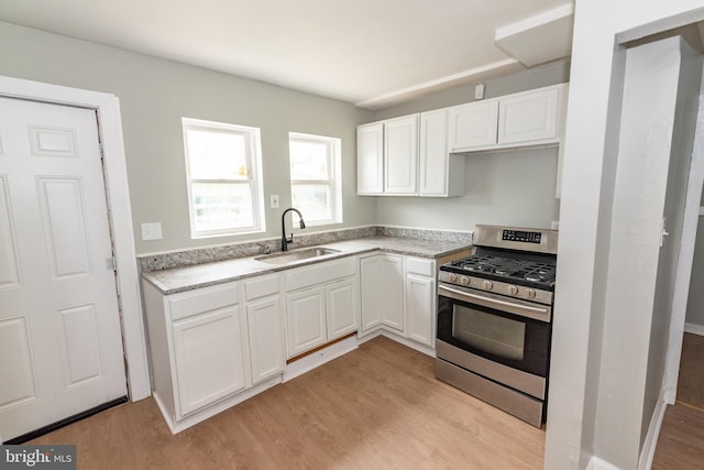631 Saint Anns Ave, Baltimore, MD 21218 - kitchen featuring stainless steel gas stove, light wood-type flooring, white cabinetry, and light stone counters