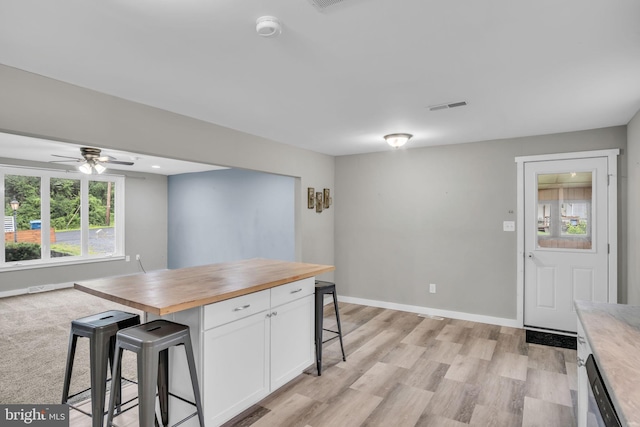 60 Gordon Dr, Carlisle, PA 17013 - kitchen featuring wood counters, a kitchen breakfast bar, white cabinetry, light wood finished floors, and a ceiling fan