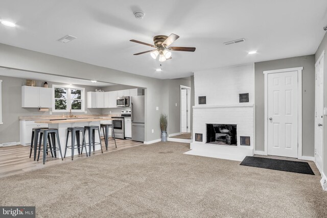 60 Gordon Dr, Carlisle, PA 17013 - living room with ceiling fan, light colored carpet, a brick fireplace, and recessed lighting