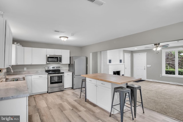 60 Gordon Dr, Carlisle, PA 17013 - kitchen with stainless steel appliances, butcher block countertops, a kitchen breakfast bar, open floor plan, and white cabinetry