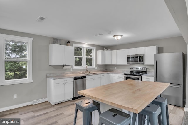60 Gordon Dr, Carlisle, PA 17013 - kitchen with appliances with stainless steel finishes, light countertops, healthy amount of natural light, and white cabinetry