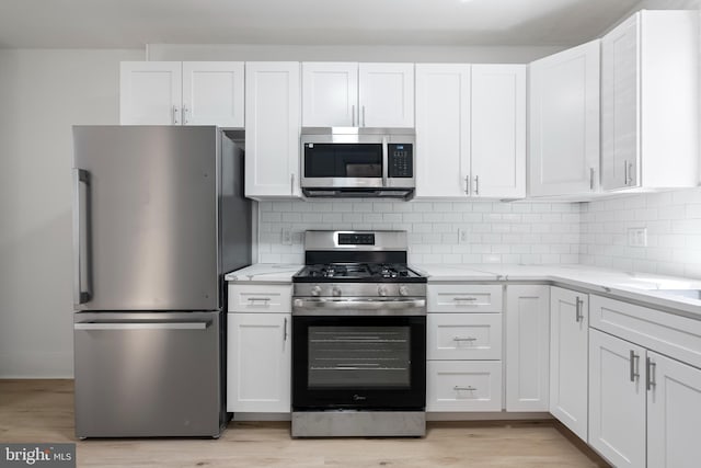 1439 S 28th St, Philadelphia, PA 19146 - kitchen with appliances with stainless steel finishes, white cabinetry, and light stone counters