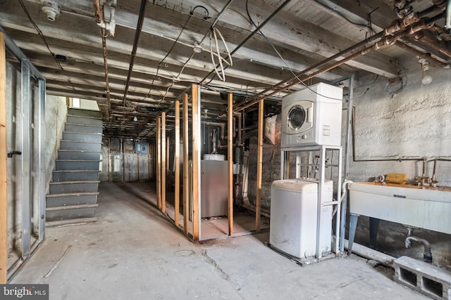 1439 S 28th St, Philadelphia, PA 19146 - unfinished basement with stacked washer and clothes dryer, stairs, and a water softener