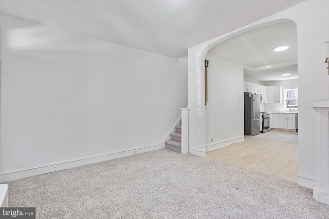 1439 S 28th St, Philadelphia, PA 19146 - unfurnished living room with arched walkways, light colored carpet, stairs, and recessed lighting