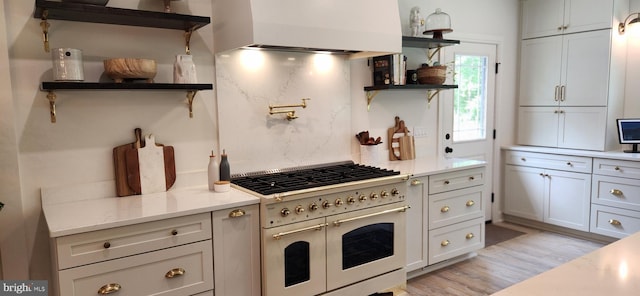73 Bayberry Rd, Princeton, NJ 08540 - kitchen with range with two ovens, open shelves, range hood, light wood-style floors, and light stone countertops