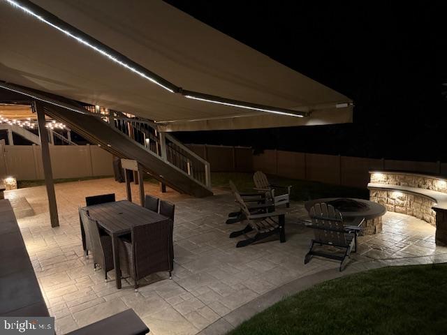 303 Petunia Way, Stafford, VA 22554 - patio at night featuring a patio area, stairs, and outdoor dining area