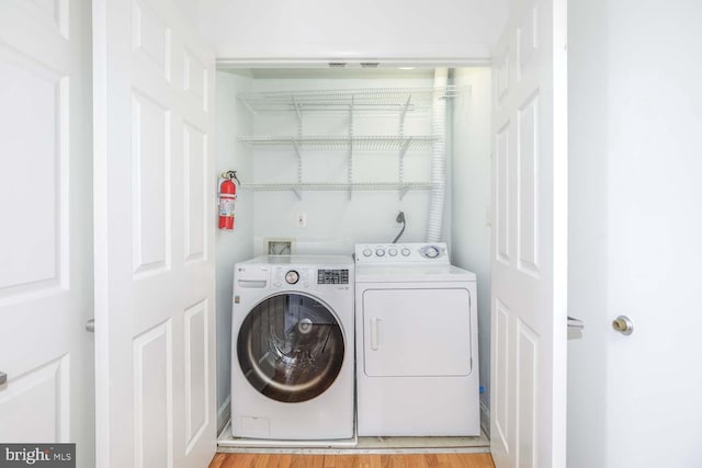 1308 Clifton St NW Unit 118, Washington, DC 20009 - laundry room with separate washer and dryer and light wood-style flooring