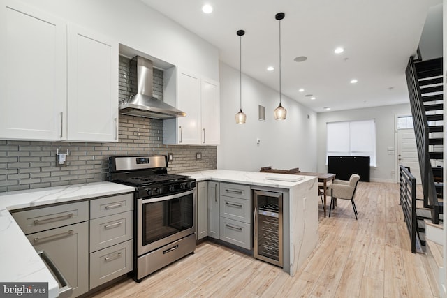 1448 N Myrtlewood St, Philadelphia, PA 19121 - kitchen with beverage cooler, stainless steel gas range oven, wall chimney exhaust hood, gray cabinets, and a peninsula