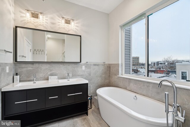 1448 N Myrtlewood St, Philadelphia, PA 19121 - bathroom with a freestanding bath, double vanity, and tile walls