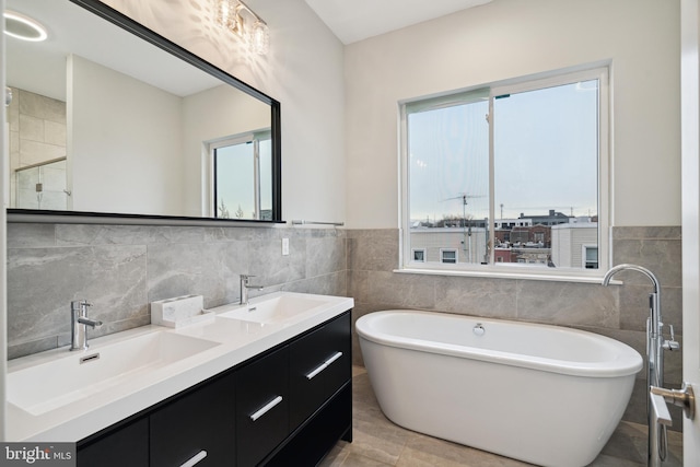 1448 N Myrtlewood St, Philadelphia, PA 19121 - full bath with tile walls, a soaking tub, double vanity, and wainscoting
