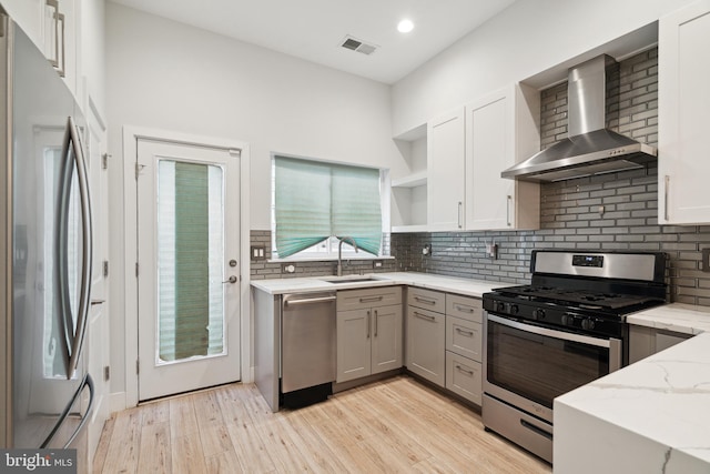 1448 N Myrtlewood St, Philadelphia, PA 19121 - kitchen featuring wall chimney exhaust hood, appliances with stainless steel finishes, open shelves, light stone countertops, and backsplash