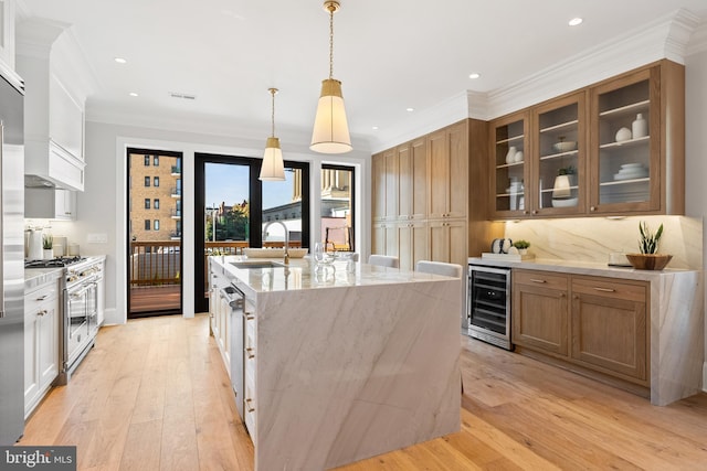 1720 15th St NW, Washington, DC 20009 - kitchen with beverage cooler, high end range, a large island with sink, light wood-style flooring, and ornamental molding