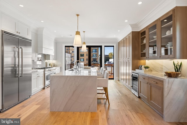 1720 15th St NW, Washington, DC 20009 - kitchen featuring premium appliances, wine cooler, light wood-type flooring, glass insert cabinets, and decorative backsplash