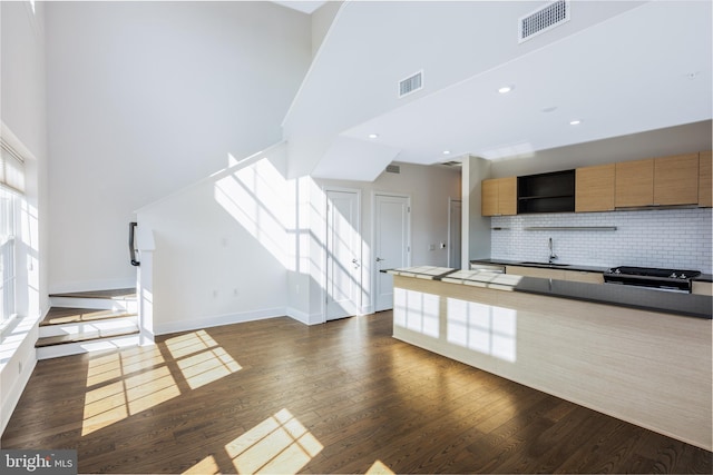 502 Diamondback Dr Unit 415, Gaithersburg, MD 20878 - kitchen featuring a high ceiling, decorative backsplash, stove, dark wood-style flooring, and open shelves