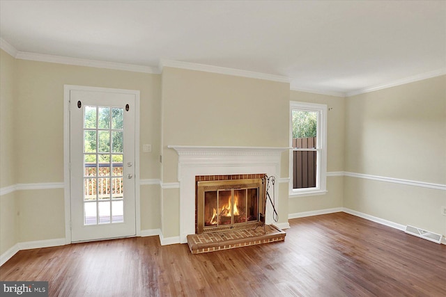 38 Fairfax Vlg, Harrisburg, PA 17112 - unfurnished living room featuring healthy amount of natural light, wood finished floors, a brick fireplace, and crown molding