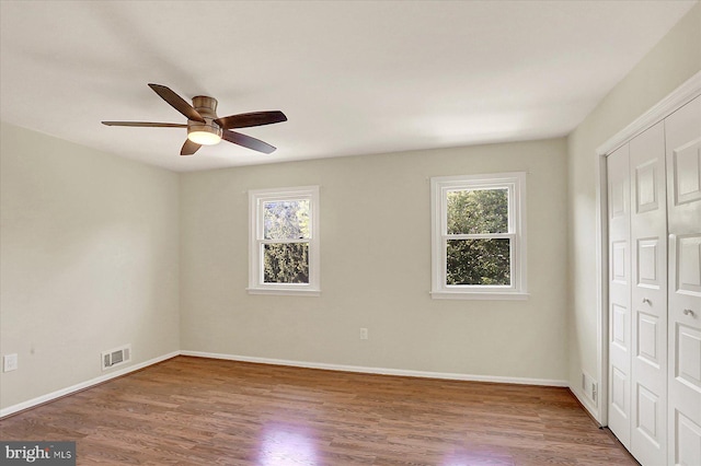 38 Fairfax Vlg, Harrisburg, PA 17112 - unfurnished bedroom with multiple windows, wood finished floors, a closet, and ceiling fan