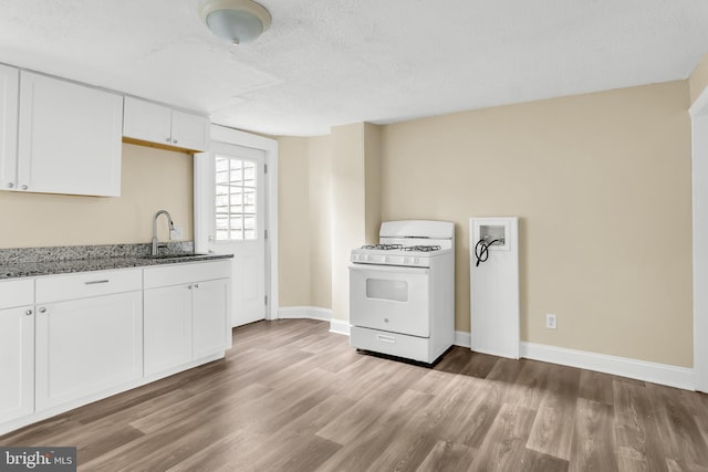 204 S Sherman St, York, PA 17403 - kitchen with gas range gas stove, dark stone counters, white cabinetry, wood finished floors, and a textured ceiling