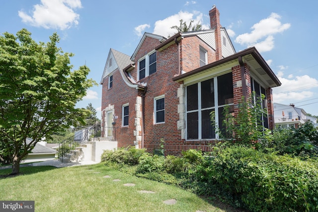 6339 Frederick Rd, Baltimore, MD 21228 - view of side of home with brick siding, a chimney, and a yard