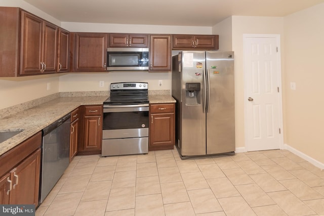 3923 Fairview Ave, Baltimore, MD 21216 - kitchen featuring appliances with stainless steel finishes, light tile patterned flooring, and light stone countertops