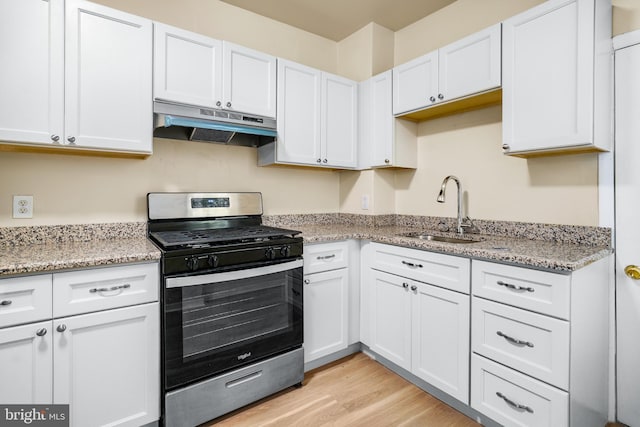 409 N Franklin St, Wilmington, DE 19805 - kitchen with gas range, under cabinet range hood, white cabinets, and light wood finished floors
