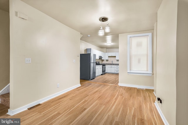 409 N Franklin St, Wilmington, DE 19805 - unfurnished living room with light wood-style floors and stairway