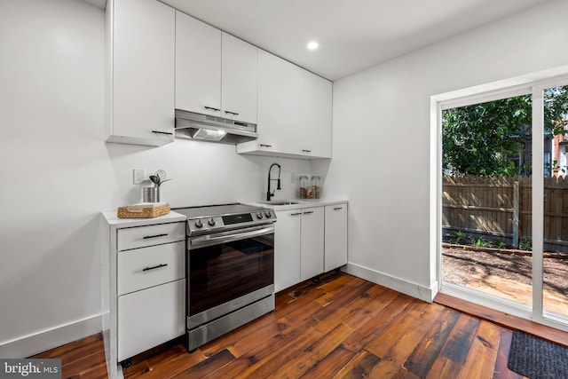 1406 Lemmon St, Baltimore, MD 21223 - kitchen with under cabinet range hood, electric stove, dark wood-style floors, white cabinets, and light countertops