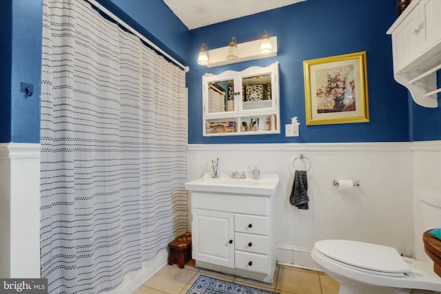 216 Hanover St, Glen Rock, PA 17327 - bathroom featuring tile patterned flooring, vanity, a wainscoted wall, tile walls, and curtained shower
