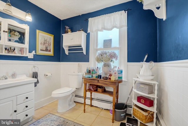 216 Hanover St, Glen Rock, PA 17327 - bathroom with a baseboard heating unit, vanity, a wainscoted wall, tile patterned flooring, and tile walls