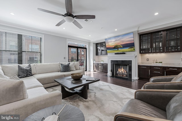 43561 Michigan Sq, Leesburg, VA 20176 - living area with ornamental molding, ceiling fan, dark wood-style floors, recessed lighting, and a glass covered fireplace