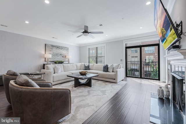43561 Michigan Sq, Leesburg, VA 20176 - living room featuring wood finished floors, crown molding, recessed lighting, a ceiling fan, and a fireplace