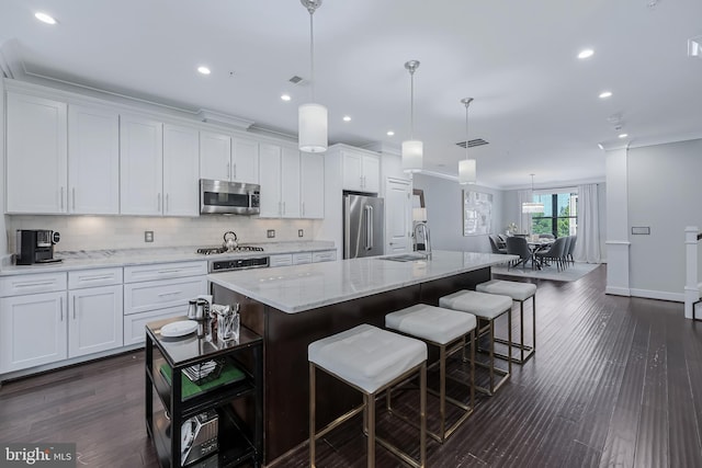 43561 Michigan Sq, Leesburg, VA 20176 - kitchen with appliances with stainless steel finishes, white cabinetry, backsplash, ornamental molding, and a large island