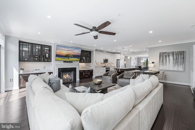43561 Michigan Sq, Leesburg, VA 20176 - living room with recessed lighting, ceiling fan, a warm lit fireplace, ornamental molding, and dark wood finished floors