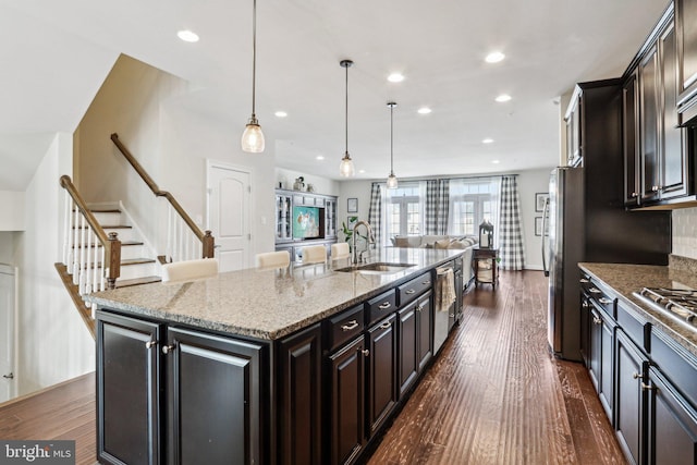 221 Patriots Path, Malvern, PA 19355 - kitchen with appliances with stainless steel finishes, a kitchen island with sink, dark wood finished floors, recessed lighting, and light stone counters