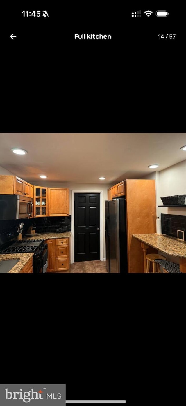 2442 S Philip St, Philadelphia, PA 19148 - kitchen with black appliances, glass insert cabinets, backsplash, and recessed lighting