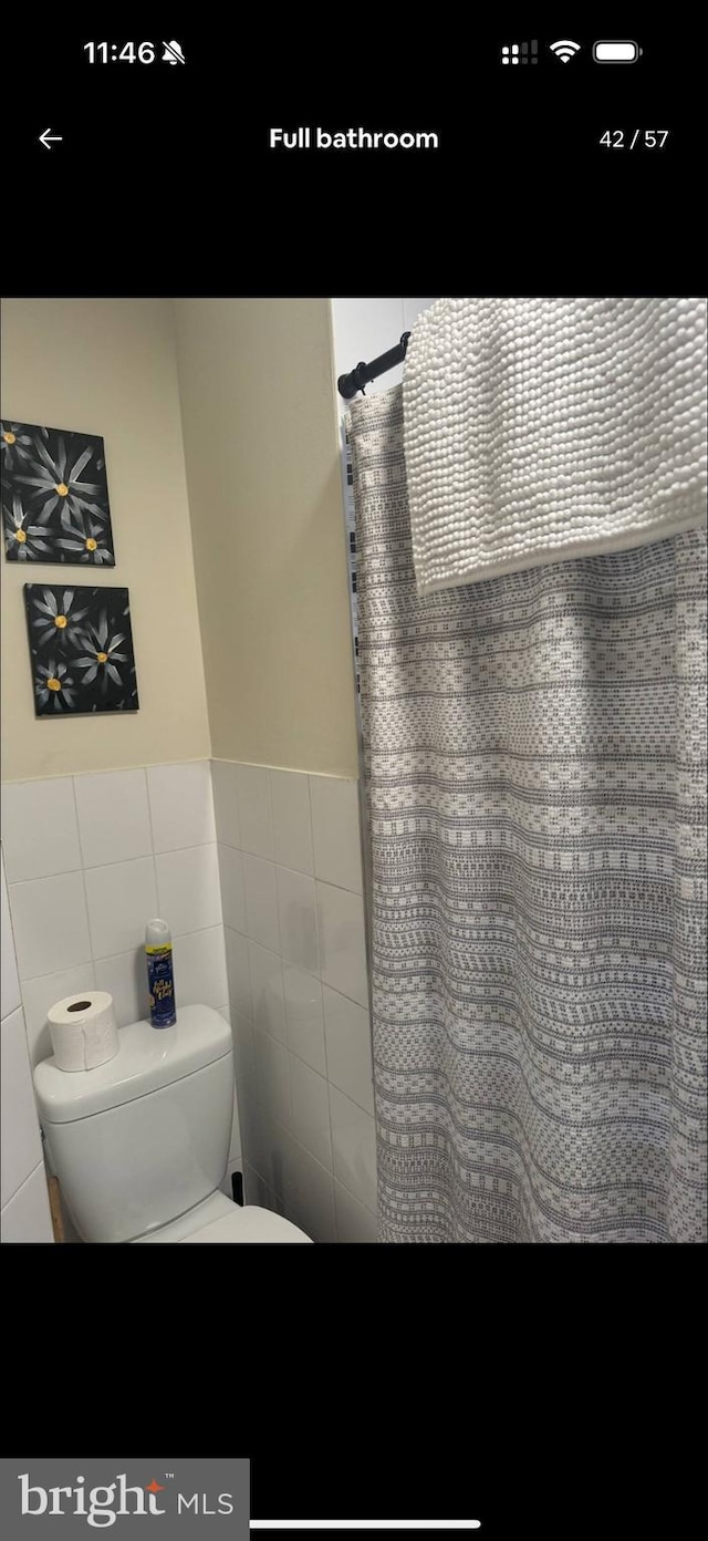 2442 S Philip St, Philadelphia, PA 19148 - full bathroom featuring tile walls, a shower with shower curtain, and wainscoting