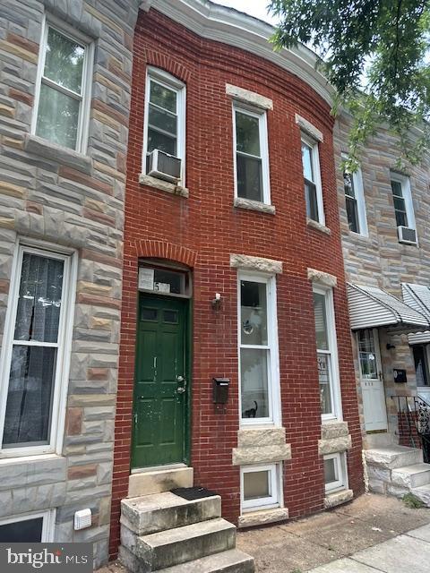 508 W 27th St W, Baltimore, MD 21211 - view of front facade featuring entry steps, stone siding, and cooling unit