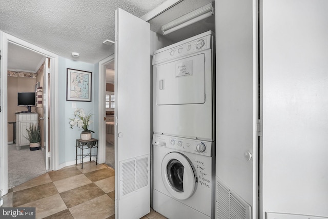 427 14th St Unit 10203, Ocean City, MD 21842 - laundry room with stacked washer and clothes dryer, a textured ceiling, and carpet