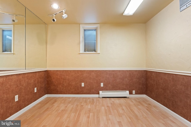 128 E Main St, Palmyra, PA 17078 - empty room featuring a baseboard heating unit, wood finished floors, track lighting, and wainscoting