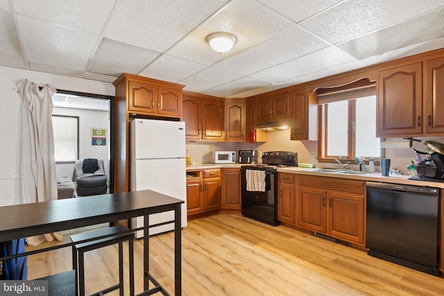 128 E Main St, Palmyra, PA 17078 - kitchen featuring black appliances, light wood-style floors, a drop ceiling, light countertops, and brown cabinets