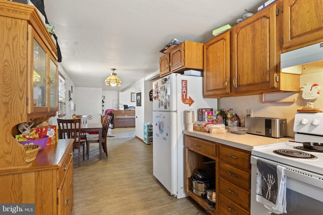 128 E Main St, Palmyra, PA 17078 - kitchen with white appliances, under cabinet range hood, light wood finished floors, brown cabinets, and glass insert cabinets