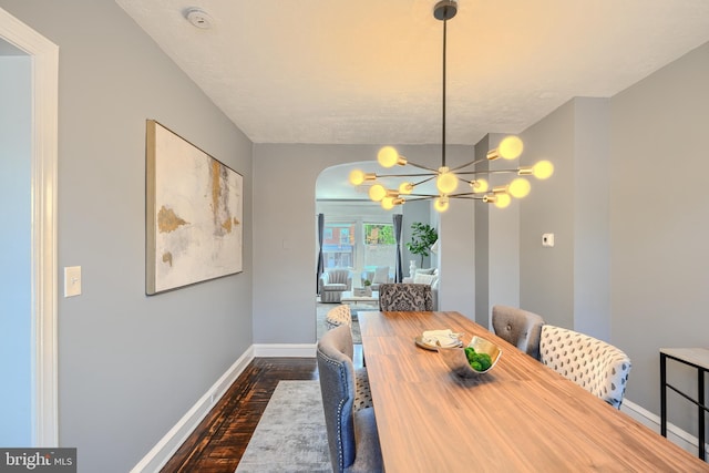 4316 Shamrock Ave, Baltimore, MD 21206 - dining space featuring dark wood-type flooring, a chandelier, and arched walkways