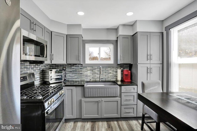 553 Wunder St Fl 1St, Reading, PA 19602 - kitchen with stainless steel appliances, gray cabinetry, dark countertops, backsplash, and recessed lighting