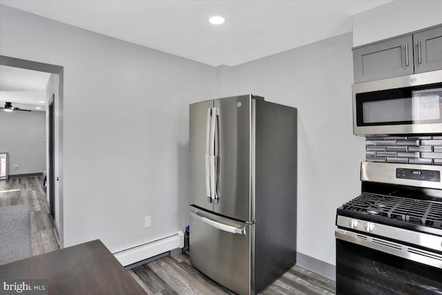 553 Wunder St Fl 1St, Reading, PA 19602 - kitchen with stainless steel appliances, baseboard heating, wood finished floors, gray cabinetry, and recessed lighting