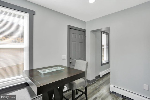 553 Wunder St Fl 1St, Reading, PA 19602 - dining room featuring a baseboard radiator, wood finished floors, and healthy amount of natural light