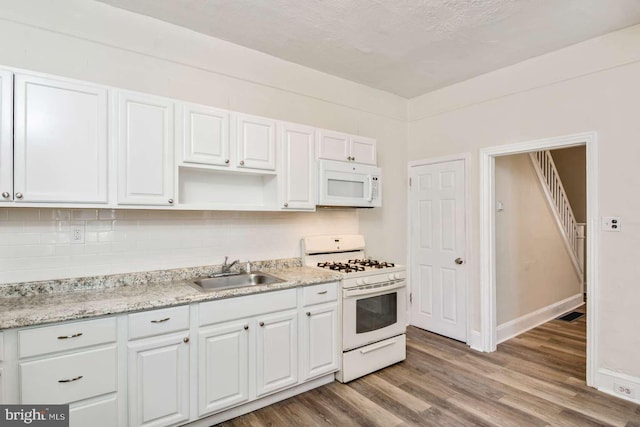 3339 N 21st St, Philadelphia, PA 19140 - kitchen featuring white appliances, wood finished floors, backsplash, white cabinetry, and open shelves