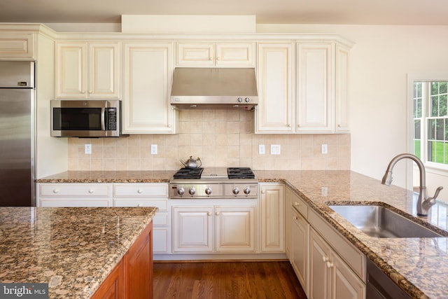 211 Twinings Ln, Wayne, PA 19087 - kitchen featuring stainless steel appliances, under cabinet range hood, cream cabinetry, and dark stone countertops