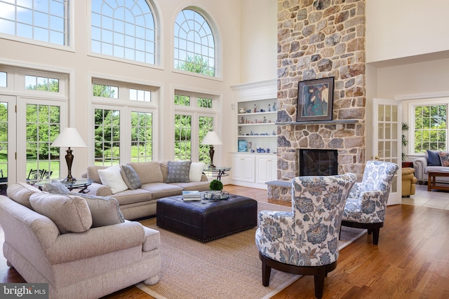 211 Twinings Ln, Wayne, PA 19087 - living room featuring a towering ceiling, a stone fireplace, and wood finished floors