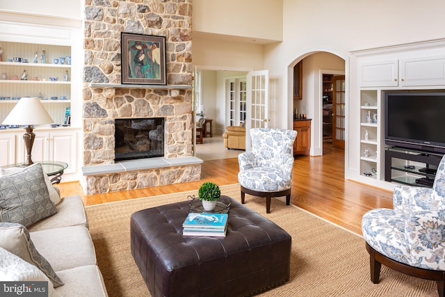 211 Twinings Ln, Wayne, PA 19087 - living area with wood finished floors, arched walkways, built in features, and a stone fireplace