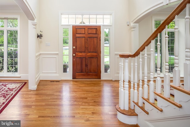 211 Twinings Ln, Wayne, PA 19087 - entryway featuring arched walkways, a decorative wall, wood finished floors, wainscoting, and stairway