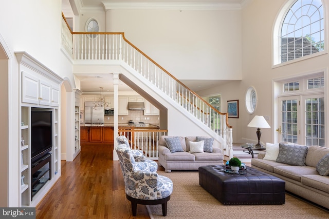 211 Twinings Ln, Wayne, PA 19087 - living room featuring a towering ceiling, dark wood-style floors, healthy amount of natural light, stairs, and crown molding